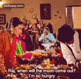 a group of people are gathered around a table with food and a man is talking to a woman .