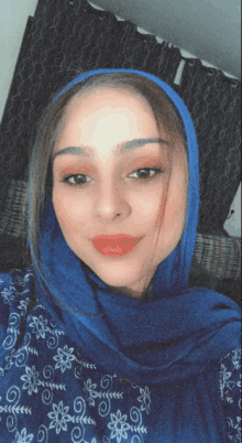 a woman wearing a blue scarf and a blue shirt