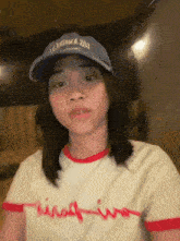 a girl wearing a hat and a t-shirt that says ' king iwo ' on it