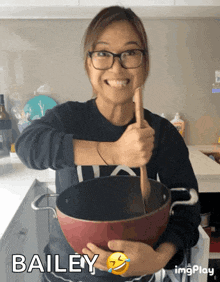 bailey is holding a pot with a wooden spoon