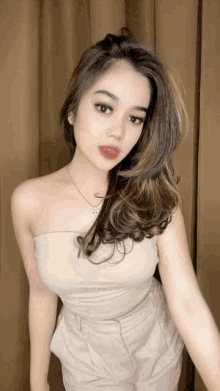 a woman is wearing a strapless top and pants