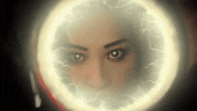 a close up of a woman 's face with a glowing circle around her face .
