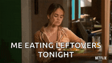 a woman is sitting at a table with a plate of food .