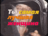 a man is looking out of a window with the words `` ты самая лучшая женщина '' in russian .