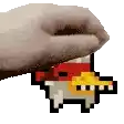 a hand is holding a pixel art piece of a cartoon character .