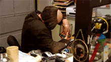 a man sits at a desk holding a jar of m & ms