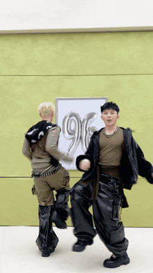 two men are dancing in front of a poster with the number 96