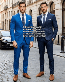 two men in blue suits are standing next to each other on a street