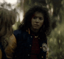 a woman wearing a blue and yellow jacket has a patch on her jacket that says ' eagle ' on it
