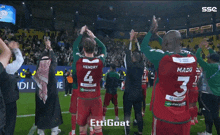 a group of soccer players on a field with their arms in the air and the words ettigoat on the bottom