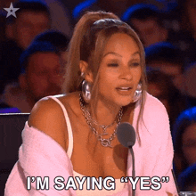 a woman is sitting in front of a microphone and saying " i 'm saying " yes