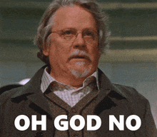 a man with glasses and a beard is standing in front of a sign that says oh god no