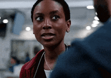 a woman with a stethoscope around her neck is talking to a man in a blue jacket .