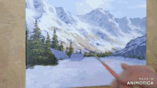 a person is painting a snowy mountain landscape on a canvas with the words made in animatica at the bottom