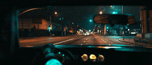 a car is driving down a street at night with a sign that says ' a ' on it