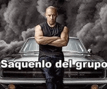 a man is standing in front of a car with his arms crossed and smoke coming out of it .