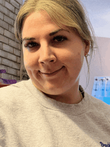a woman wearing a gray sweatshirt with the word brady on it