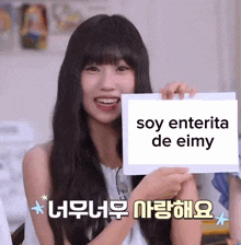 a girl holds a sign that says soy enterita de eimy