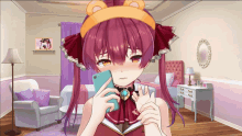 a girl with red hair and a teddy bear headband holds a cell phone