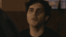 a close up of a man 's face in a dark room with his mouth open .