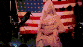 a statue in front of an american flag with a black bird