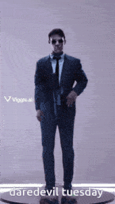 a man in a suit and tie is standing on a pedestal with the words daredevil tuesday written below him