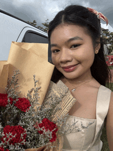 a woman holding a bouquet of red carnations with a newspaper wrapped in brown paper that says " flowers "