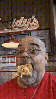 a man with a beard is eating french fries in front of a sign that says idly 's