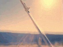 a rocket is being launched into the sky with the sun shining through the clouds