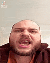 a man with a beard is making a funny face with his mouth open