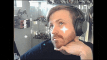 a man with a beard wearing headphones with a white star on his face