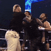 two men are wrestling in a ring with a referee standing between them