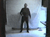 a man standing in a room with a white cloth behind him that says i.e.i.