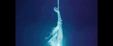 a woman in a black dress is holding a light in her hands in front of a pole .