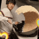 a man is cooking rice in a wok on a stove .