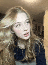 a woman with long blonde hair is wearing a sweater that says ' a ' on it