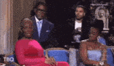 a woman in a red dress is sitting in front of a man in a suit .