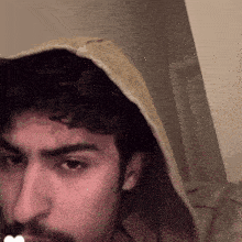 a man with a beard is wearing a yellow hoodie