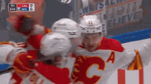 a group of hockey players are celebrating a goal against cal