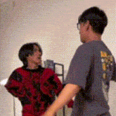 two people are standing next to each other in a room .