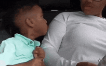 a little boy is kissing a woman 's cheek while sitting in a car