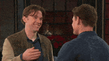two young men are hugging each other and smiling