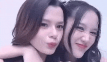 two young women are posing for a picture together .