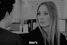 a man and a woman are looking at each other in a black and white photo and the woman is saying do n't .