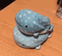 a stuffed whale is sitting on top of a wooden table .