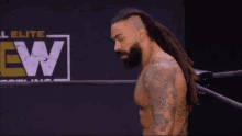 a man with dreadlocks is standing in front of a sign that says ew