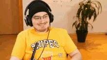 a man wearing headphones and a yellow shirt that says snipes on it