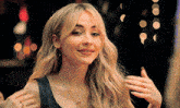 a woman with blonde hair is wearing a necklace and a ring