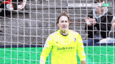 a female soccer player wearing a yellow shirt that says badenova on it