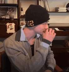 a man wearing a black beanie with the letters u2 on it